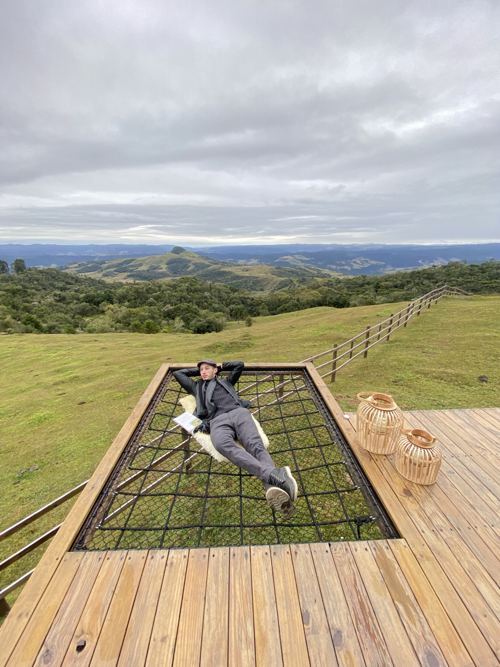 Leonardo Hunt descansando em rede com vista para as montanhas