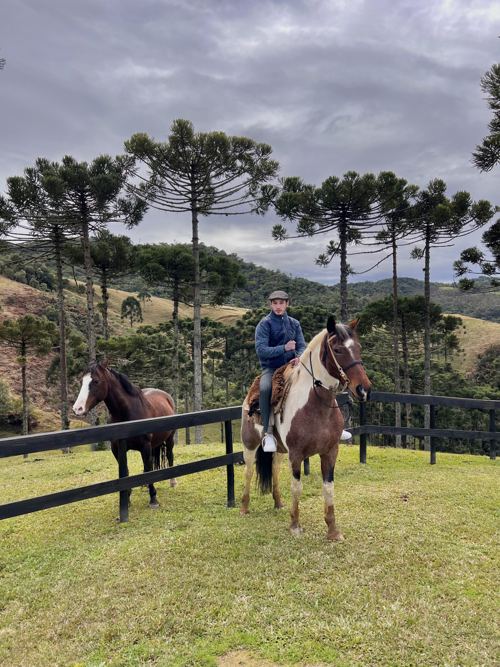 Leonardo Hunt andando a cavalo em meio a araucárias
